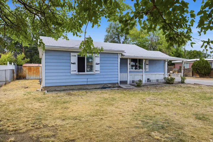 Blue siding exterior with white window shutters and a covered porch with white railing