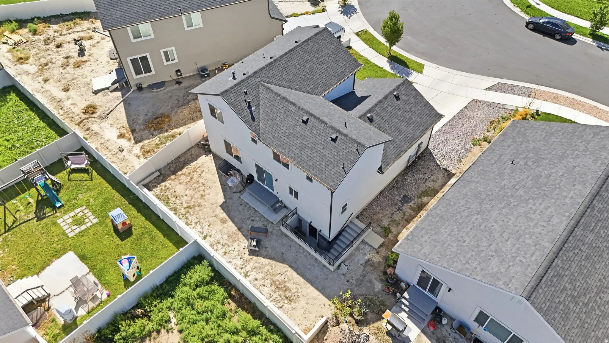 Contemporary two-story exterior with a gray shingle roof and a concrete patio