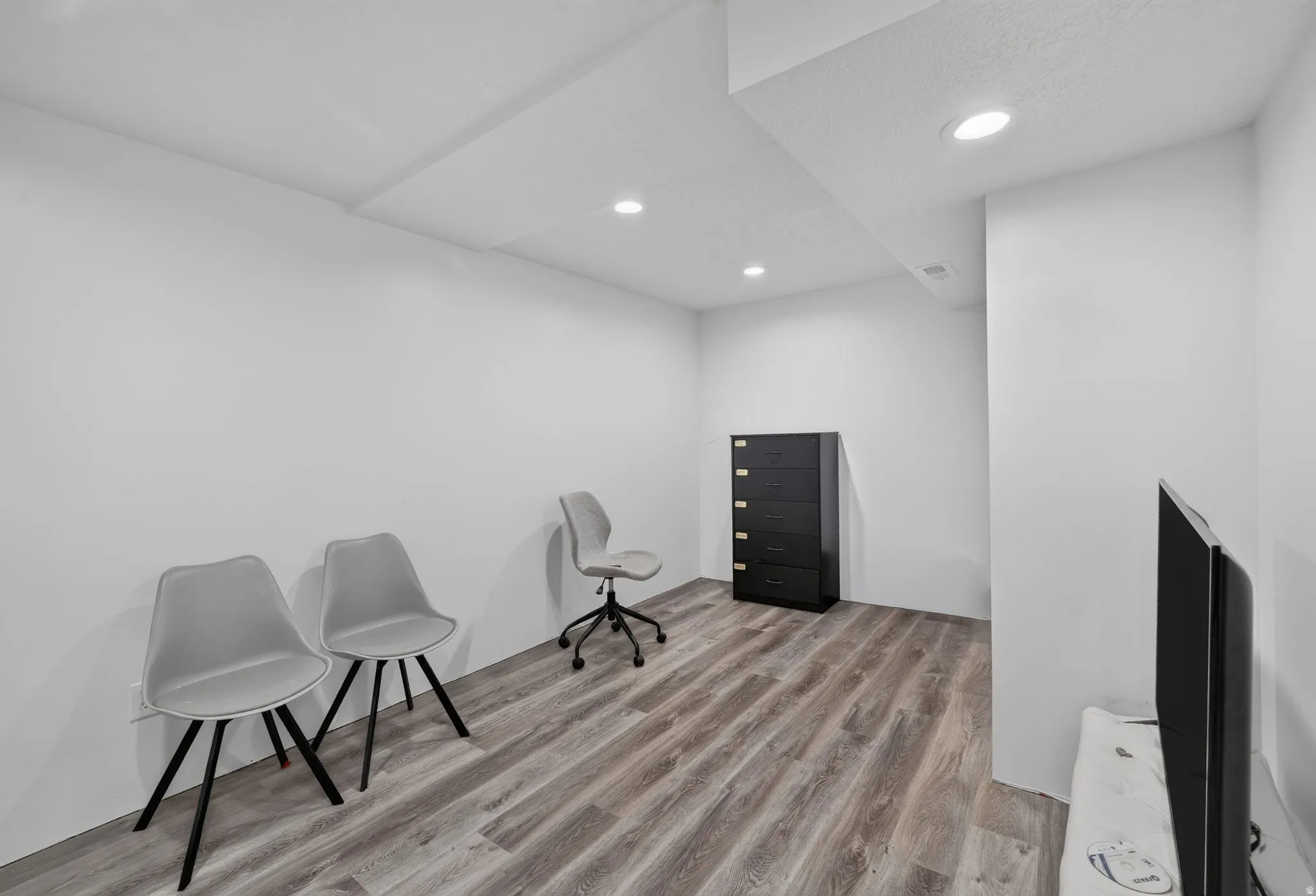 Recessed lighting, light-toned walls, wood-finish flooring, and white ceiling
