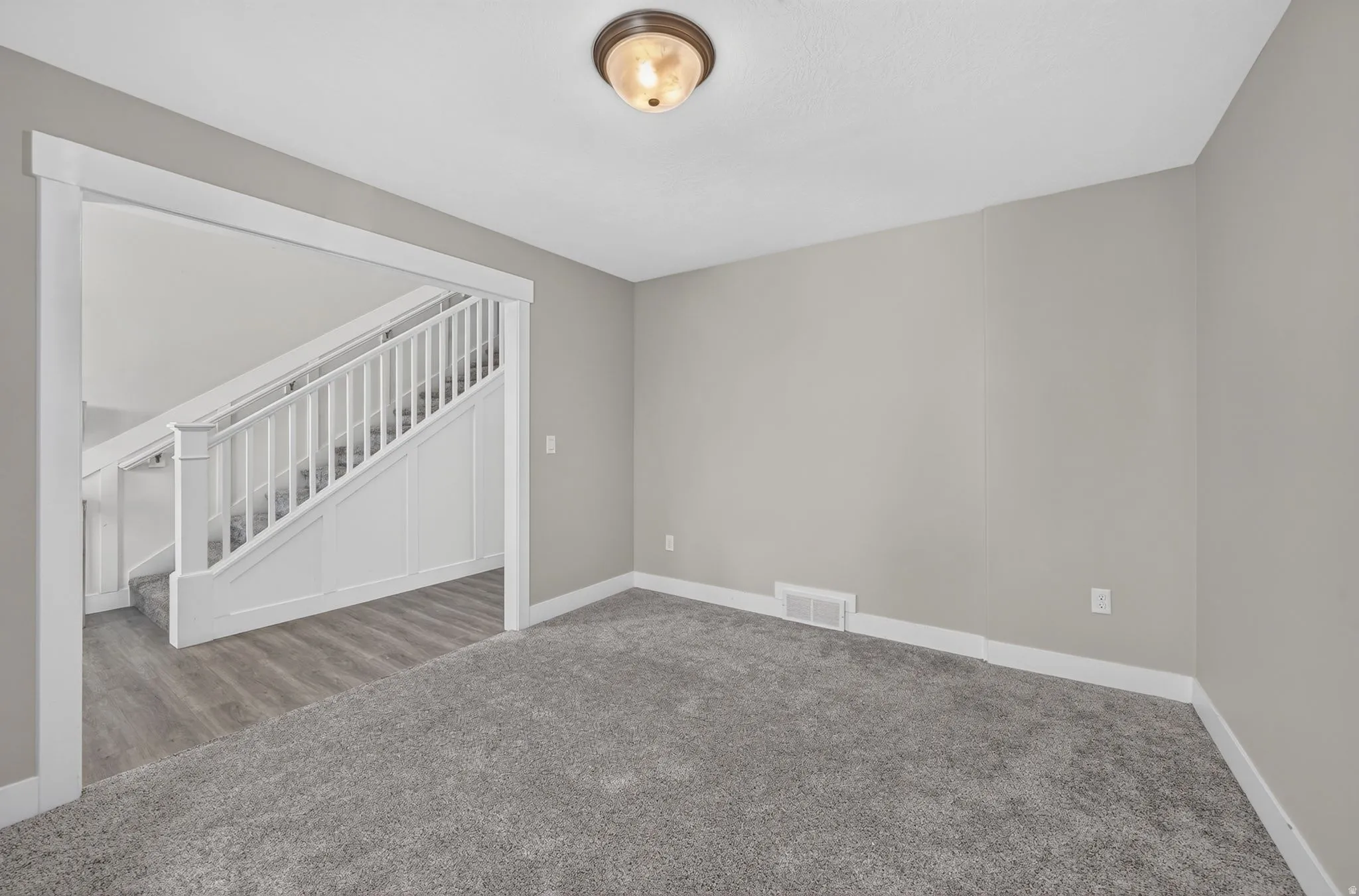Spacious room with gray wall paint and plush gray carpeting