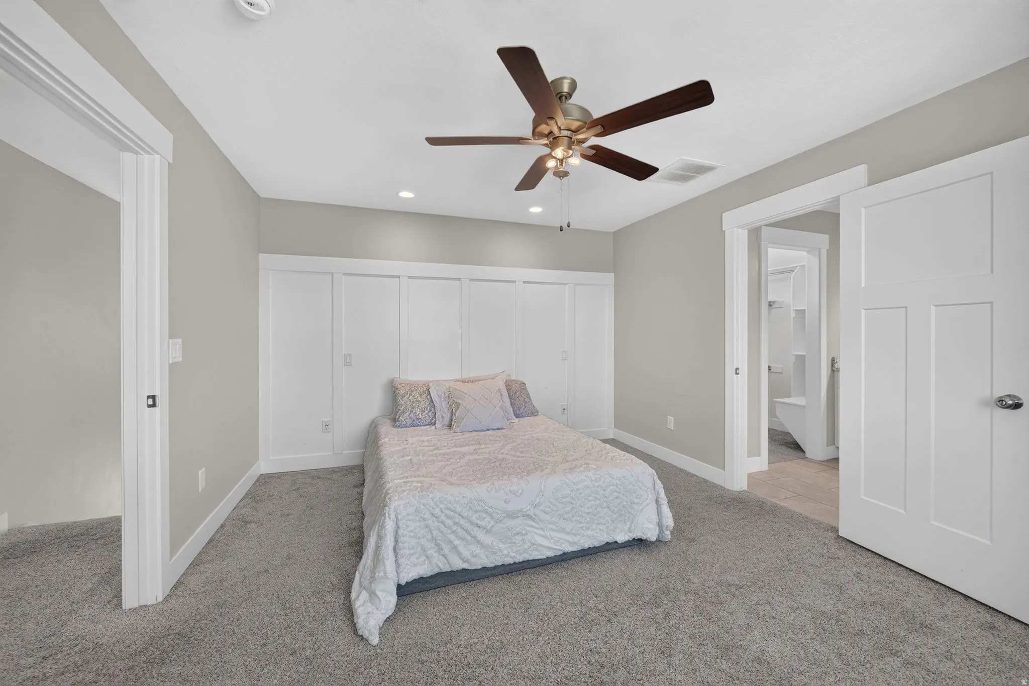 Wall-to-wall carpeting, recessed ceiling lighting, and a ceiling fan with integrated lighting