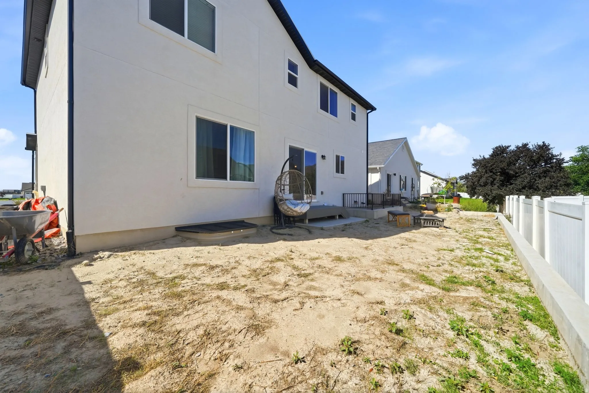 Rear exterior with white stucco finish and dark trim windows