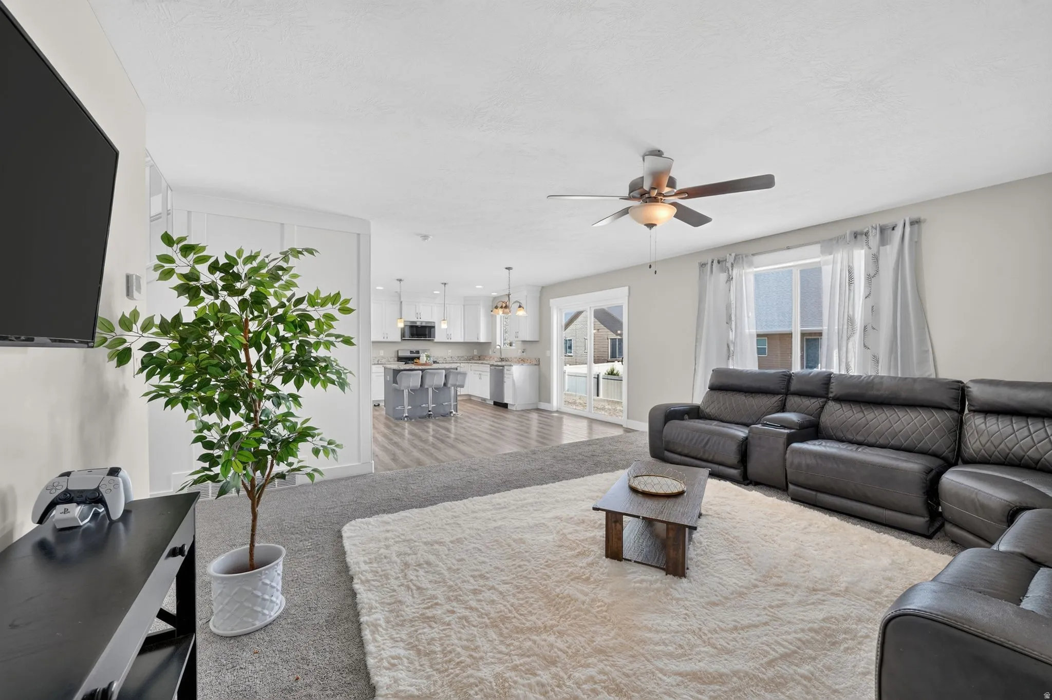 Open concept living space featuring a ceiling fan, recessed lighting, and durable wood-finish flooring