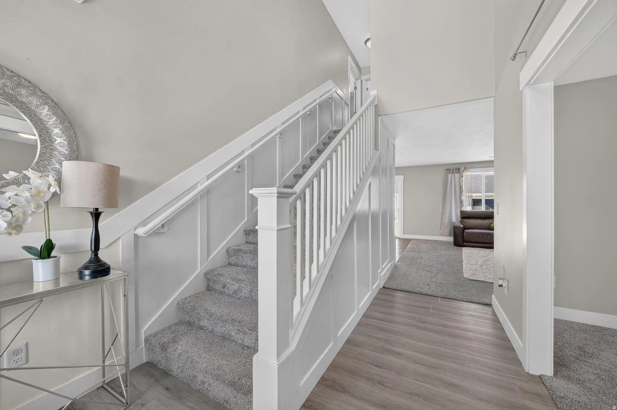 Staircase featuring wainscoting and carpeted treads