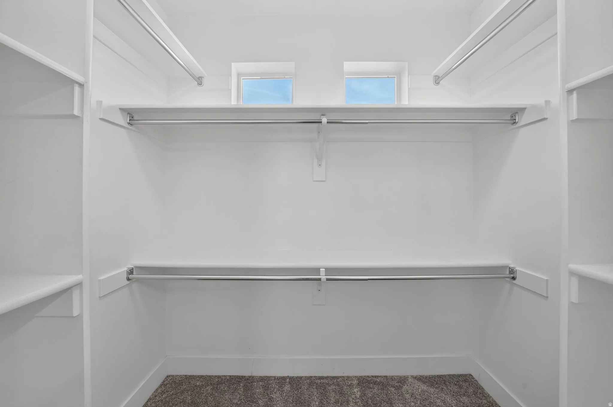 Built-in shelving, chrome hanging rods, and twin transom windows