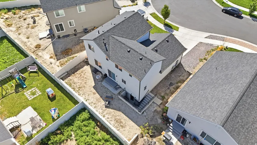 Contemporary two-story exterior with a gray shingle roof and a concrete patio