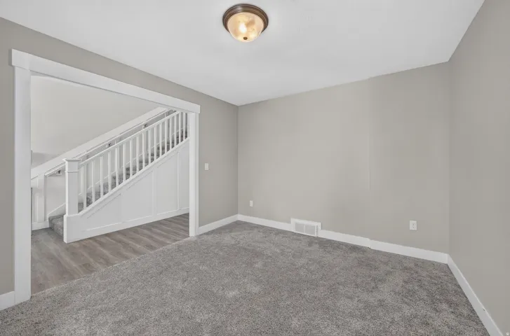 Spacious room with gray wall paint and plush gray carpeting