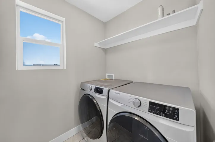 White trim window, light gray wall finish, built-in white shelving, and tile flooring