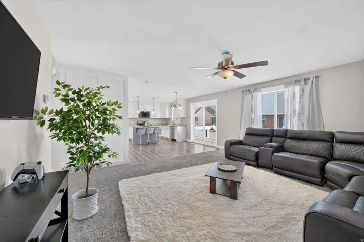 Open concept living space featuring a ceiling fan, recessed lighting, and durable wood-finish flooring