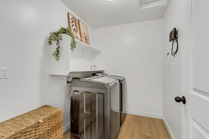 Laundry area featuring light wood-finish flooring and white walls