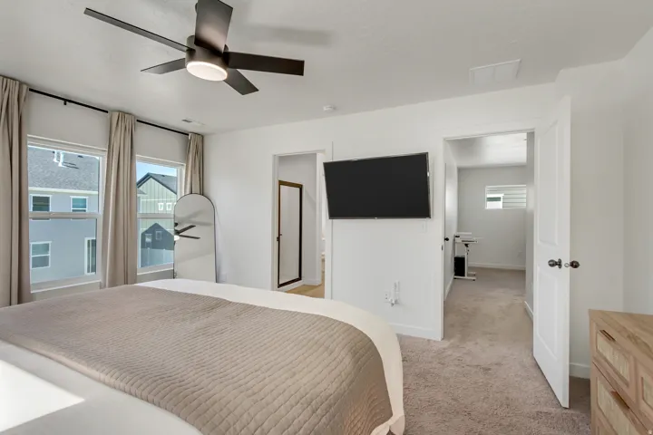 Recessed lighting, ceiling fan with integrated light, multiple windows, wall-mounted television, and neutral carpet