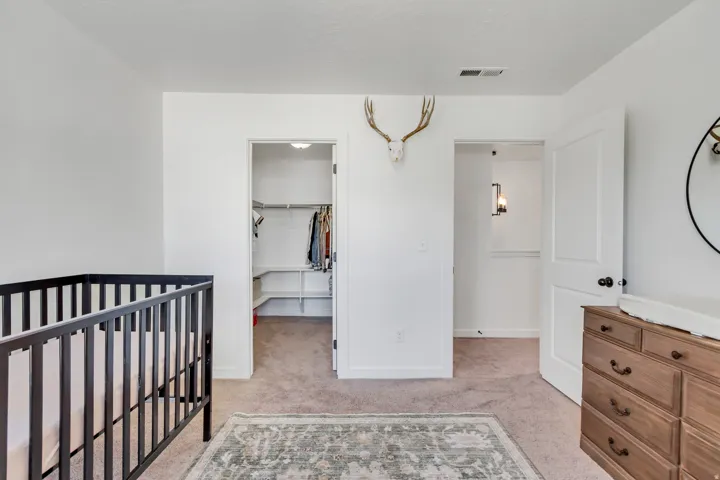 Bright nursery offering versatile space with neutral finishes, carpeted flooring, and abundant natural light