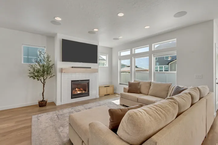 Contemporary fireplace with white tile surround and wood mantel