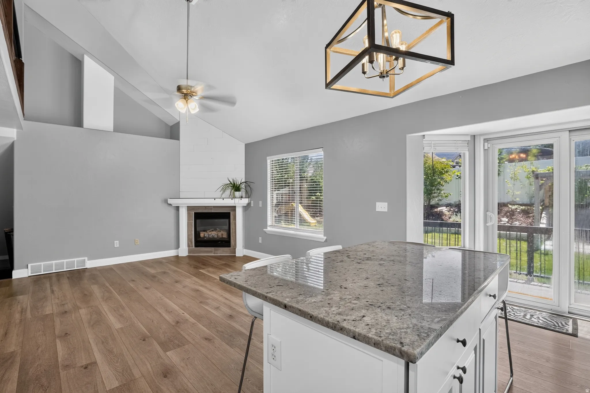 Kitchen island with a granite countertop, featuring white cabinetry and black hardware