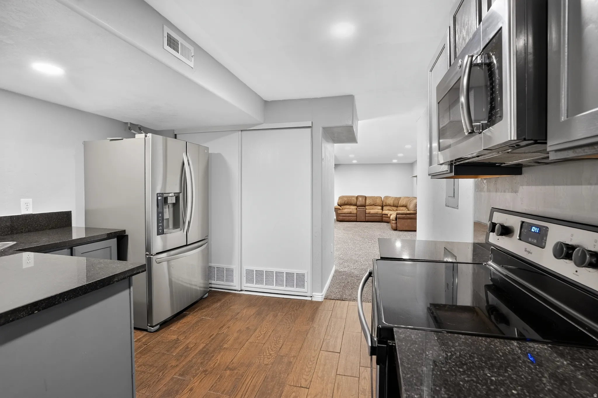 Kitchenette featuring dark speckled countertops and wood-finish flooring