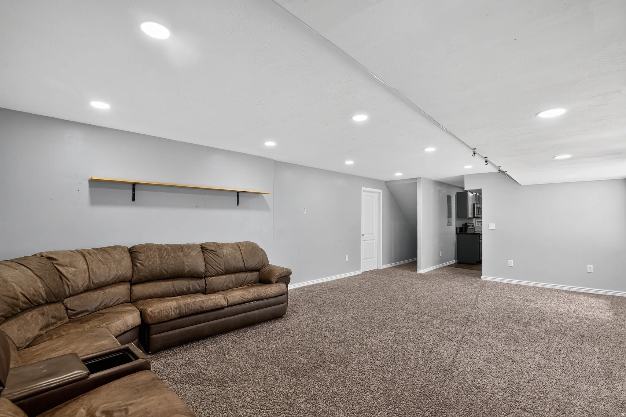 Spacious interior with neutral gray walls and brown carpeting