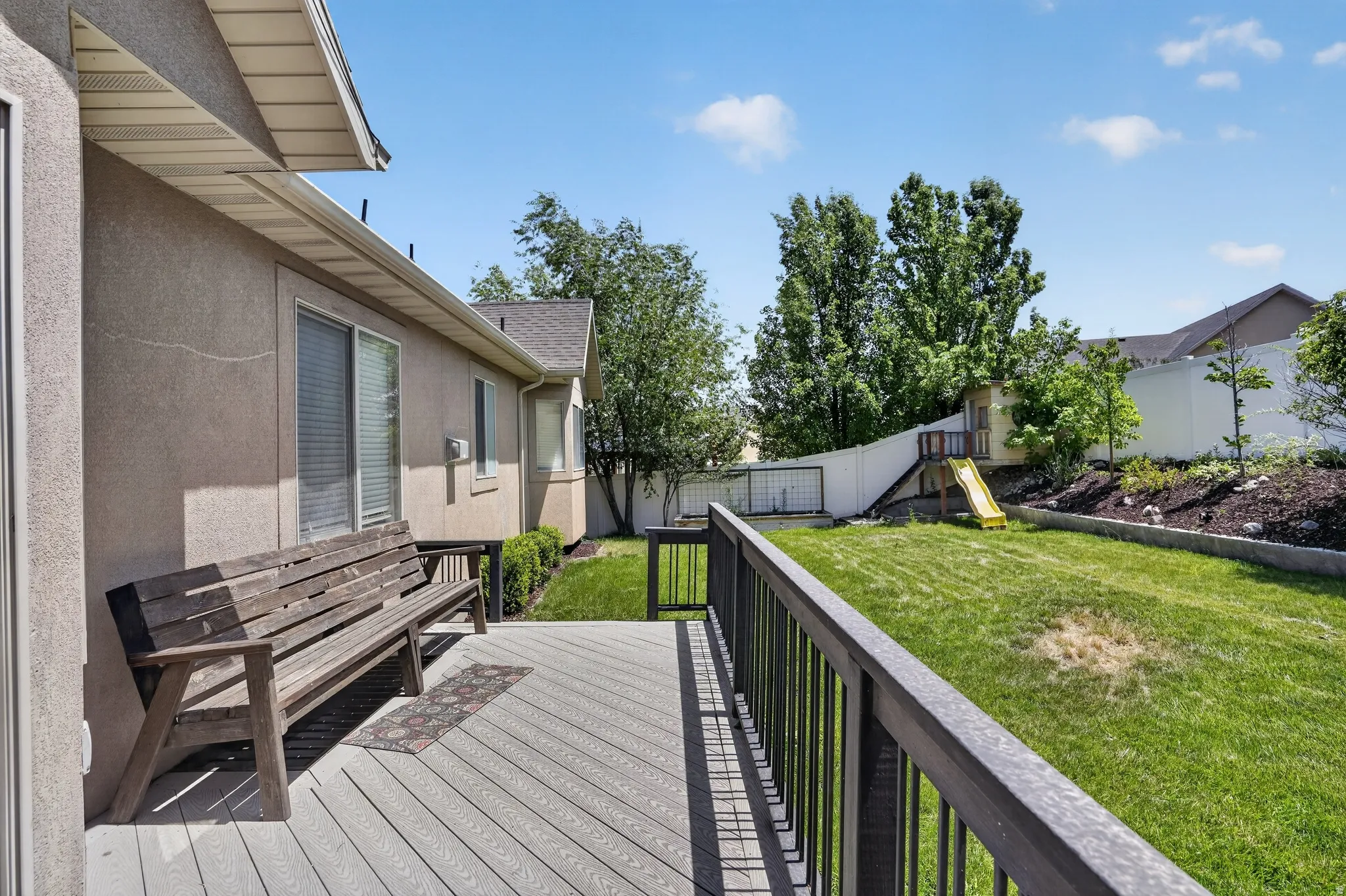 Expansive outdoor deck featuring wood-finish composite decking and a dark railing