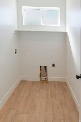 Dedicated utility space with wood-finish flooring, a high-set window, and an integrated shelf