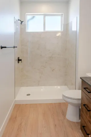 Walk-in shower with light-toned wall tile, clear glass enclosure, and matte black fixtures