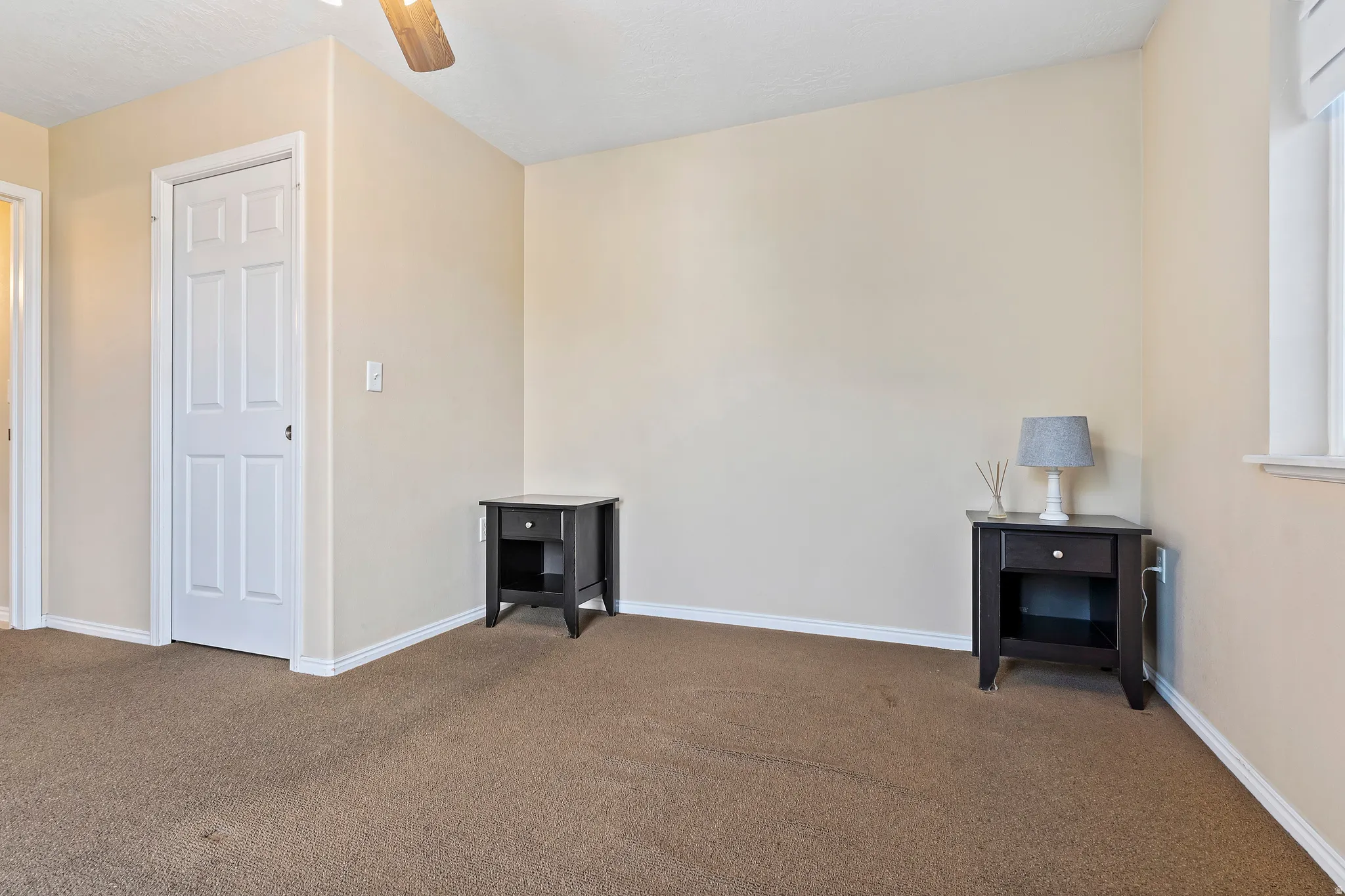 Wall-to-wall carpeting and a ceiling fan with light fixture