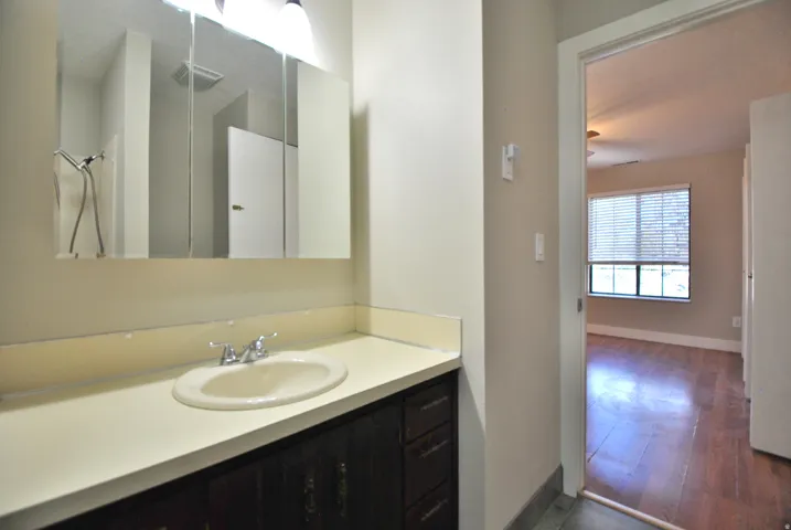Bathroom vanity with a white countertop, an undermount sink, and a chrome faucet