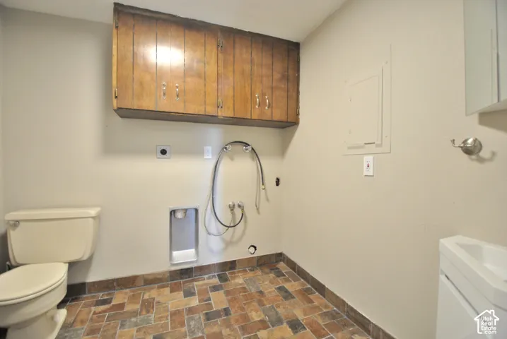 Built-in wood-finish cabinetry, tile flooring, and a white toilet