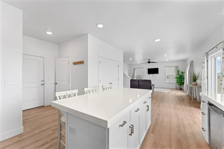 Kitchen island with a light-toned countertop, white cabinetry, and brushed nickel hardware