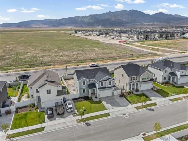 Two-story residence with attached garage, concrete driveway, and front lawn