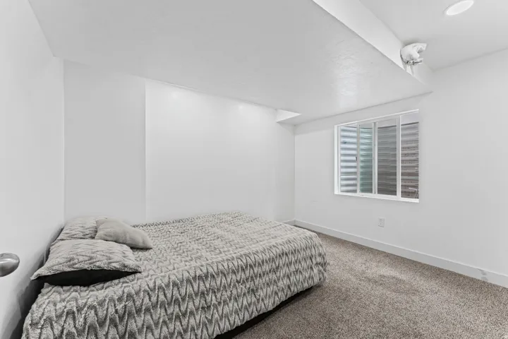 Carpeted flooring, recessed lighting, and a window with horizontal blinds