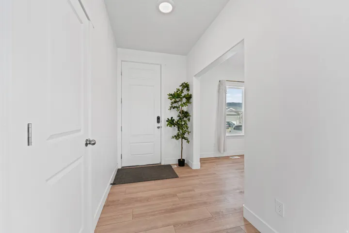 White interior doors, recessed ceiling lighting, wood-finish flooring, and white trim