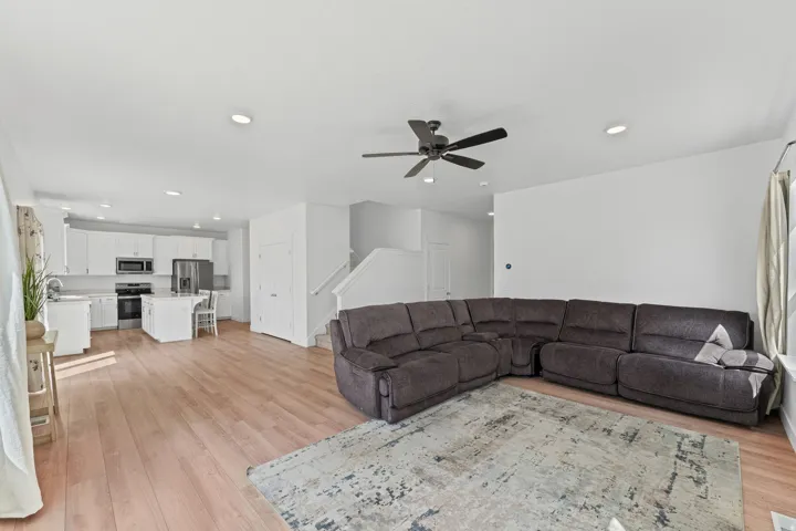 Open-concept living area featuring wood-finish flooring, recessed lighting, and a ceiling fan