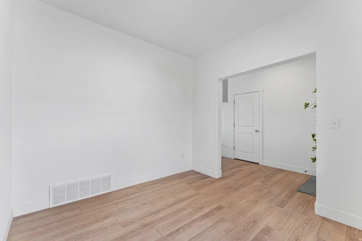 Wood-finish flooring, white walls, and a wide entryway