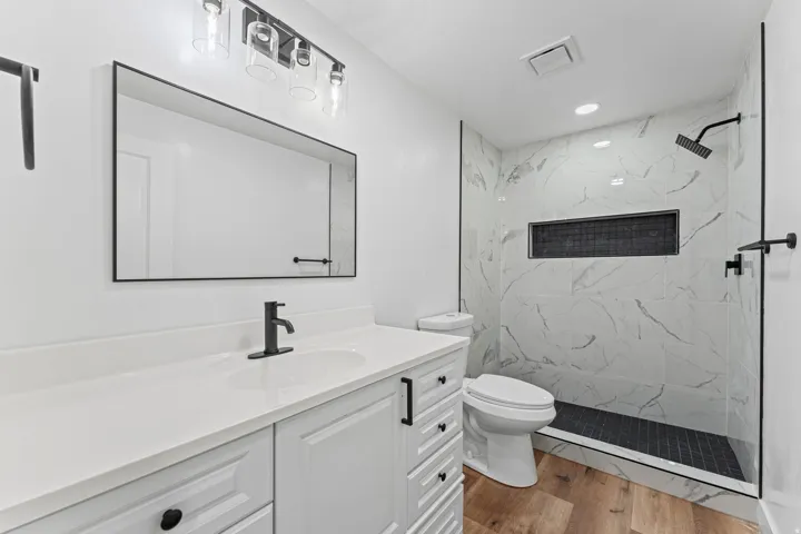 White vanity with integrated sink and matte black faucet