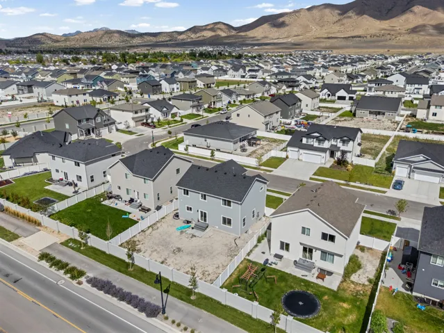 Expansive neighborhood featuring a consistent architectural style, mountain backdrop, and paved roads