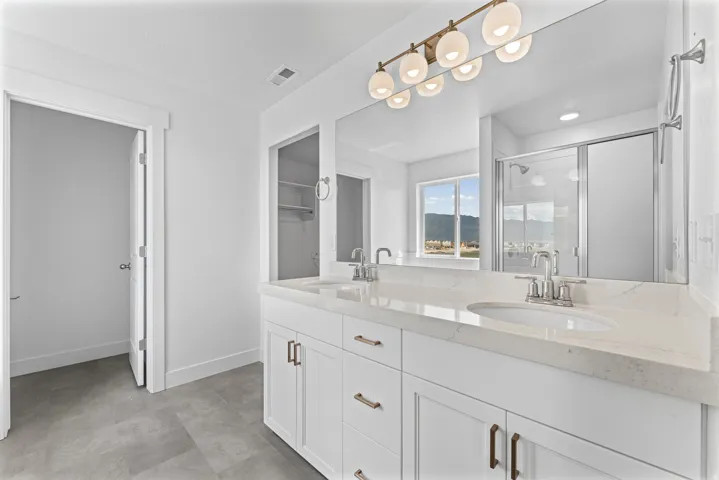 Dual vanity with white cabinetry, integrated sinks, and polished chrome fixtures