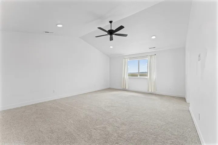 Vaulted ceiling, recessed lighting, ceiling fan, carpeting, and a window with white drapes