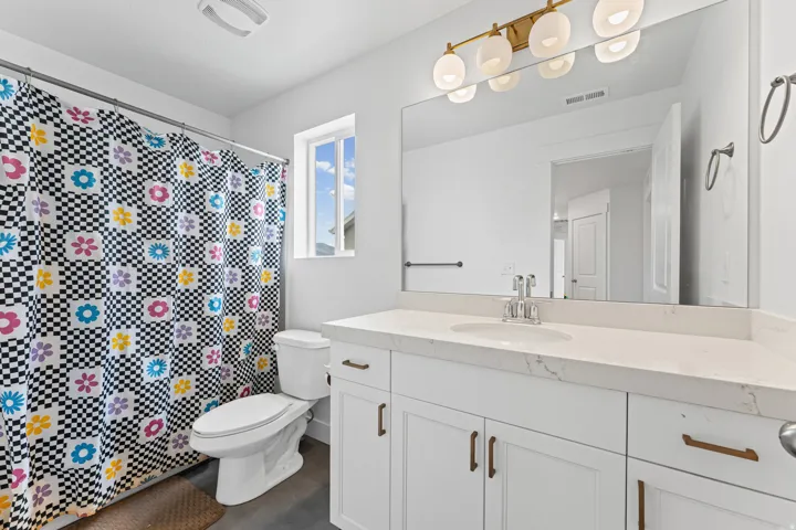 White vanity with integrated sink, polished chrome faucet, and quartz countertop