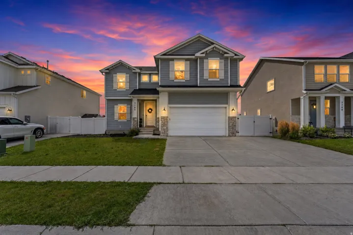Two-story residence featuring a two-car garage, stone accents, and a covered entry