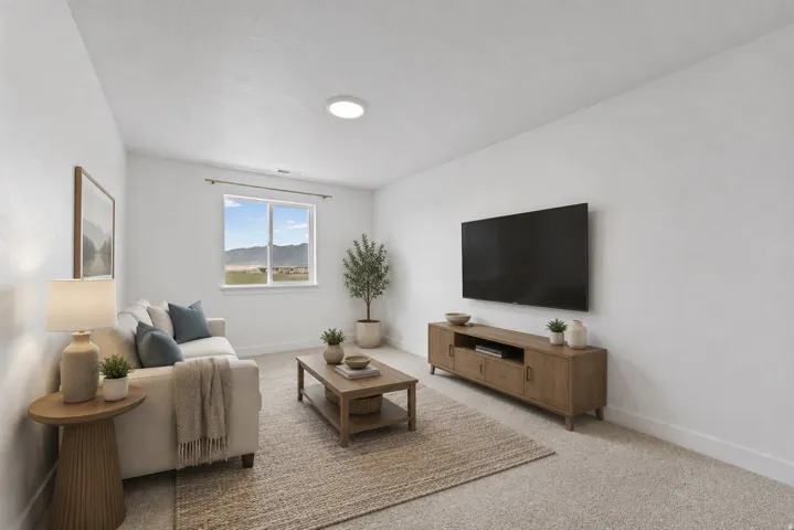 Recessed ceiling lighting, white walls, light-colored carpeting, a large window, and a wood-finish media console