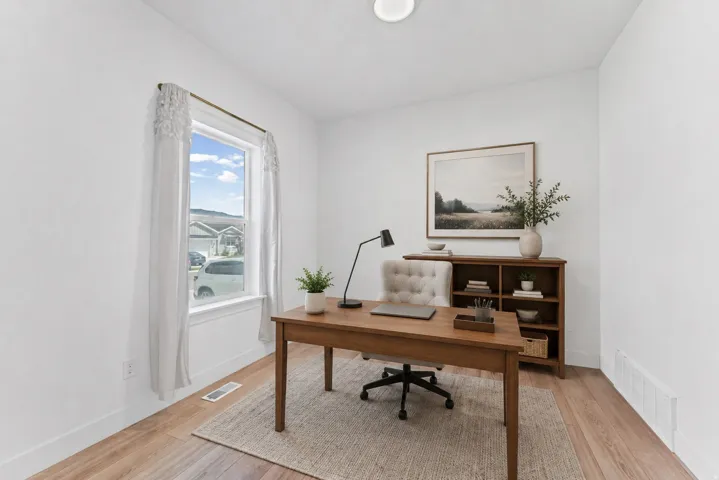 Recessed ceiling light, hard surface flooring, white walls, and a window with white trim