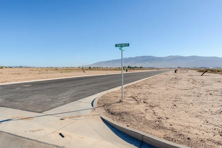 Newly paved asphalt road and concrete curb with a street sign