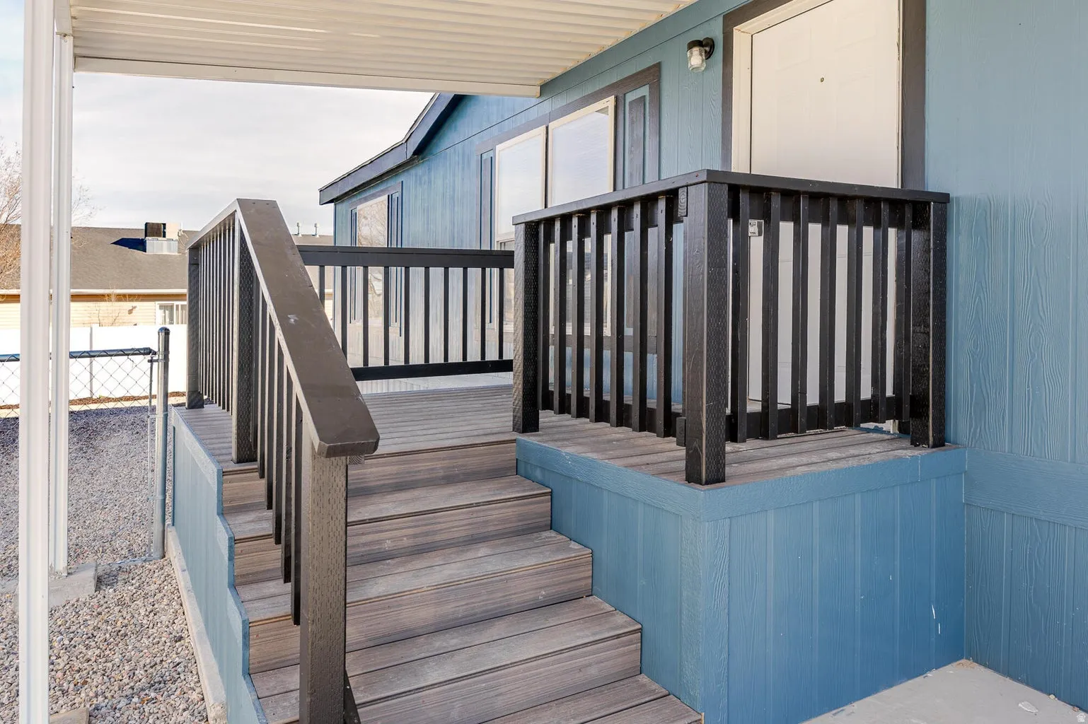 Covered porch with wood-finish steps and black railings