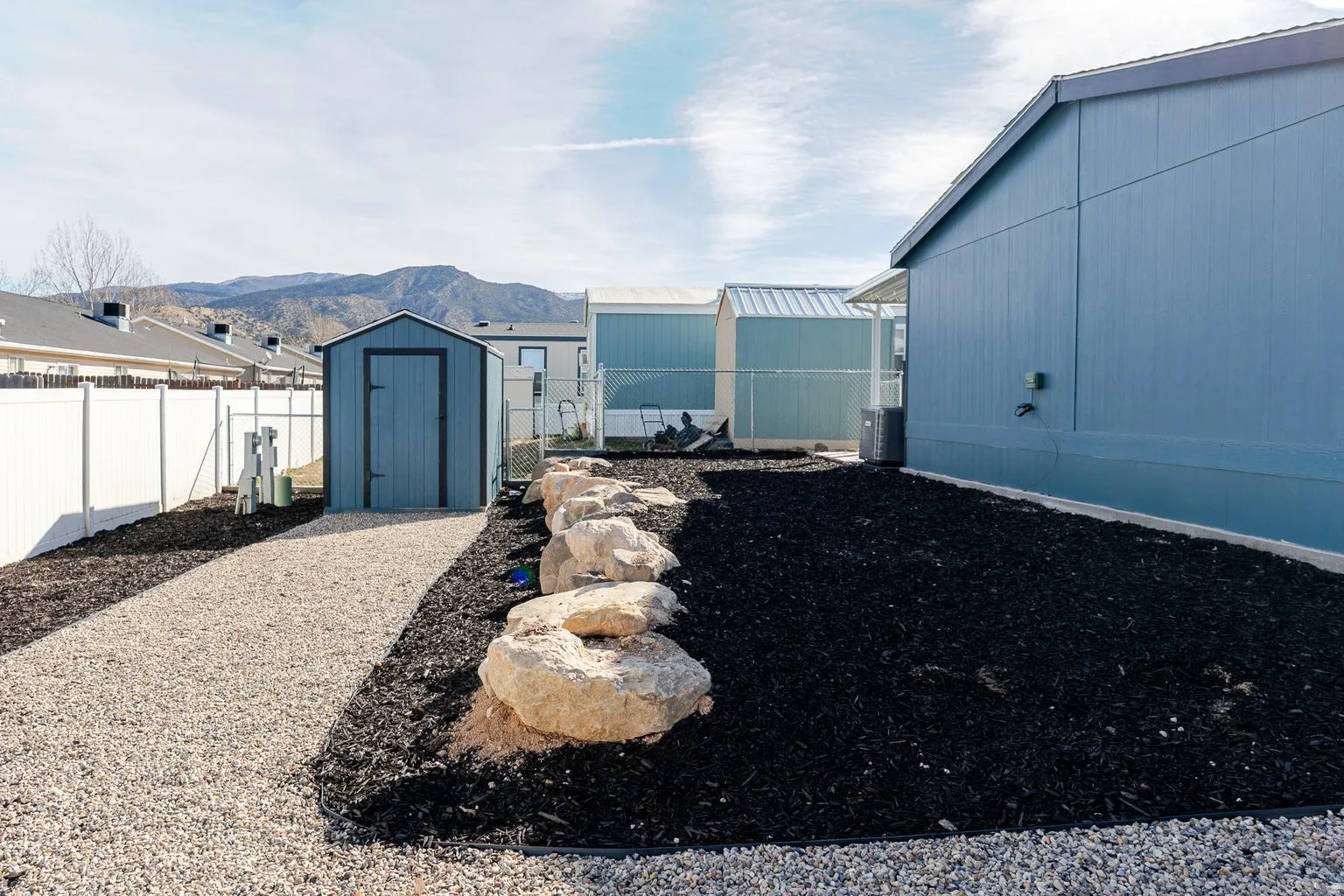 Gravel pathway with a perimeter fence and a storage shed