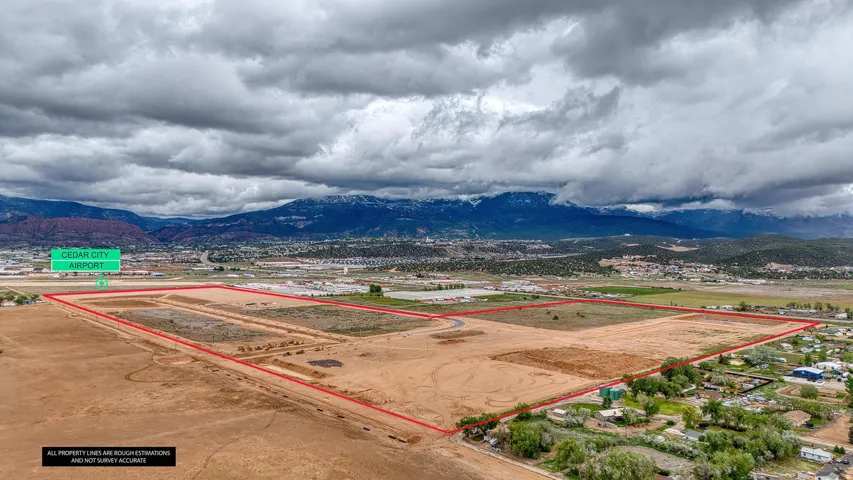 Expansive land parcel with surrounding development and distant mountain range backdrop