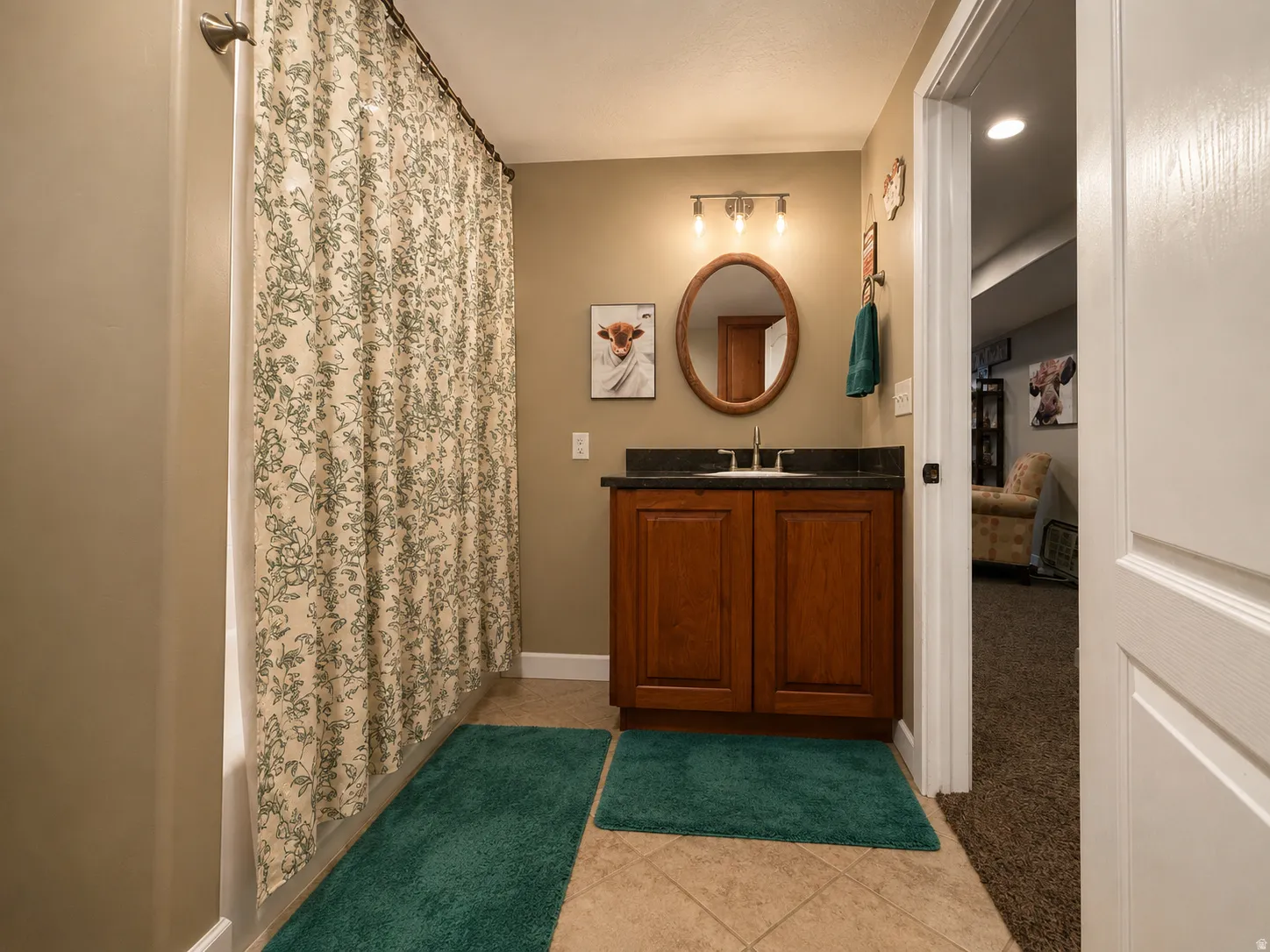 Wood-finish vanity with a dark countertop and undermount sink