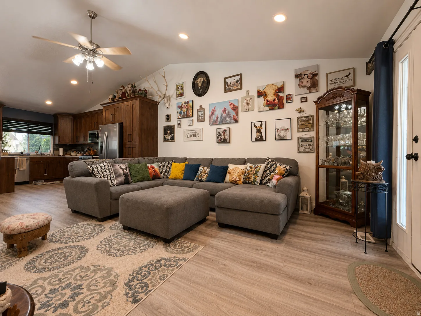 Cathedral ceiling with a ceiling fan, recessed lighting, and dark wood cabinetry with stainless steel appliances