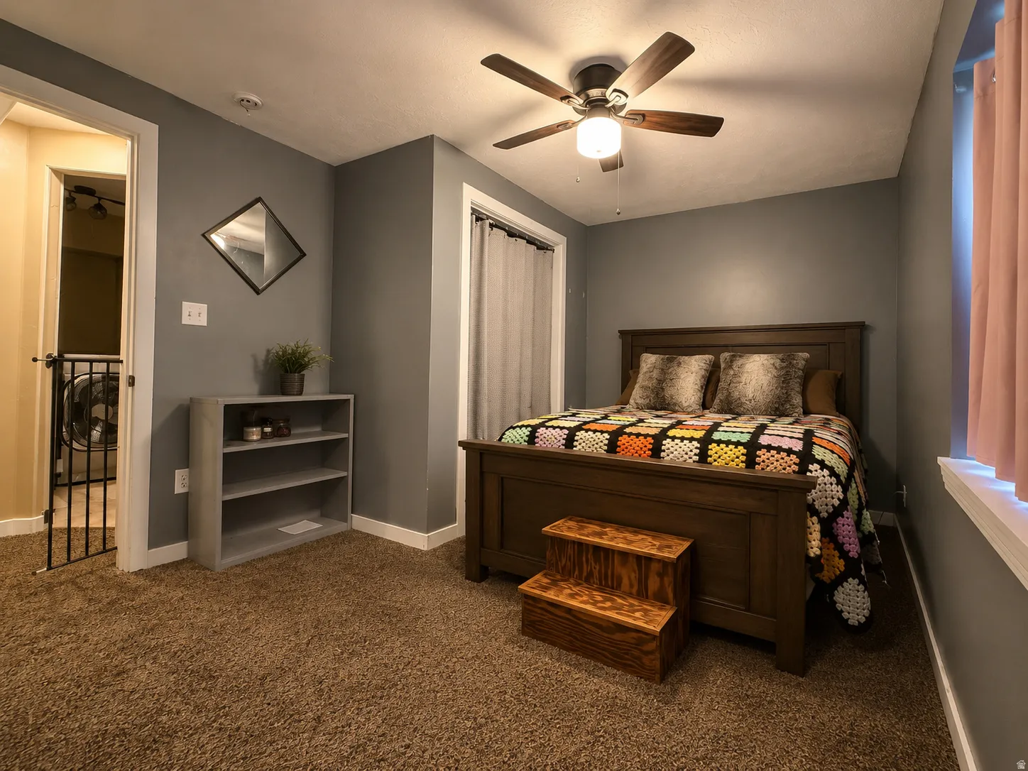 Carpeted room with a ceiling fan light fixture and a window