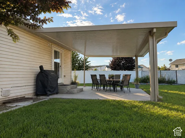 Expansive concrete patio with a full-coverage awning structure, offering an exterior living space
