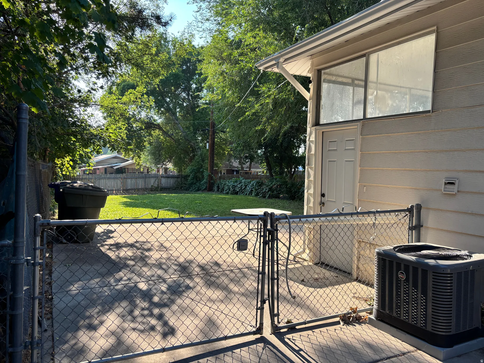 Concrete patio with chain-link fencing and gate