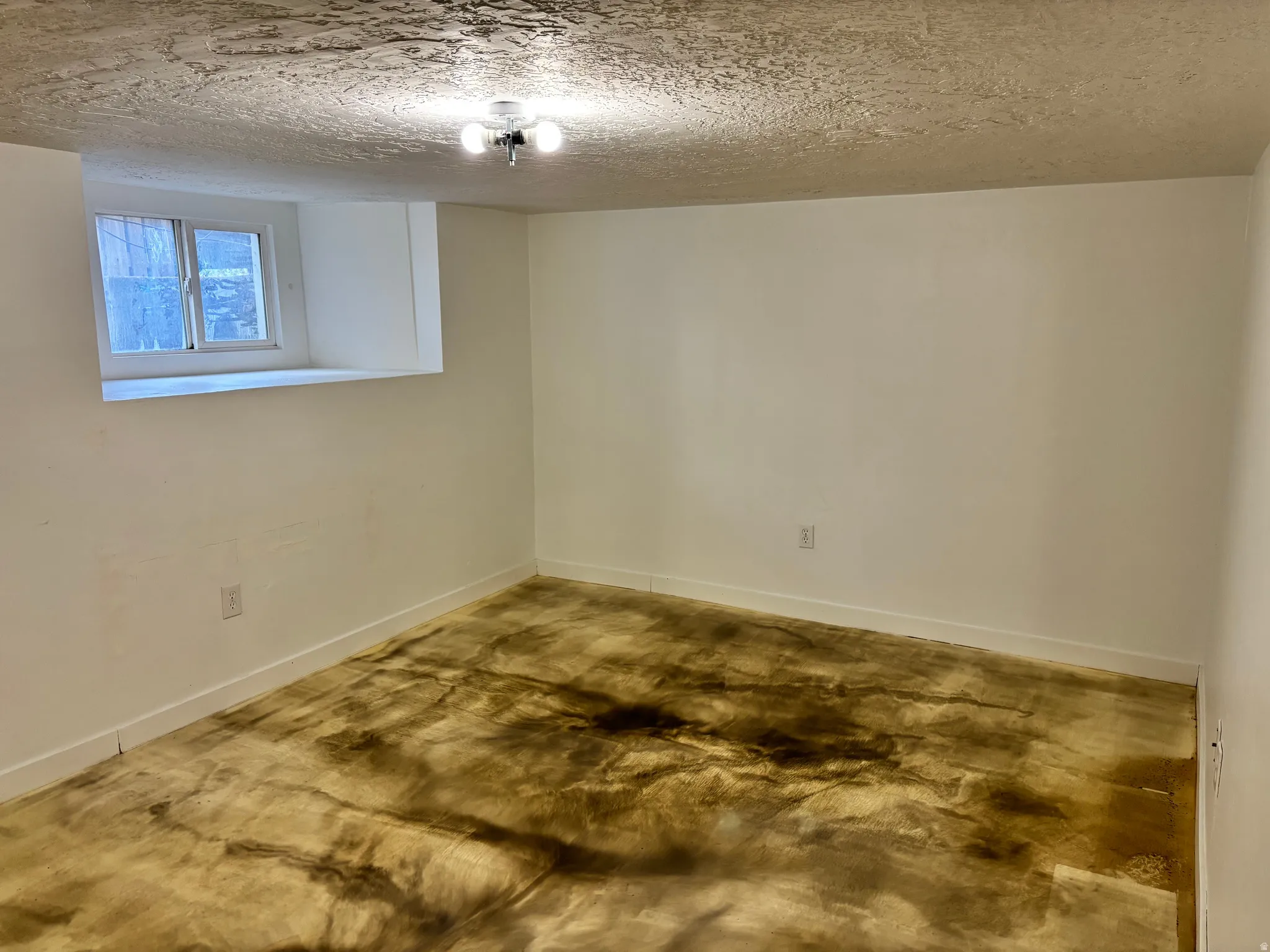 Room featuring white painted walls, a flush-mount ceiling light, and a window